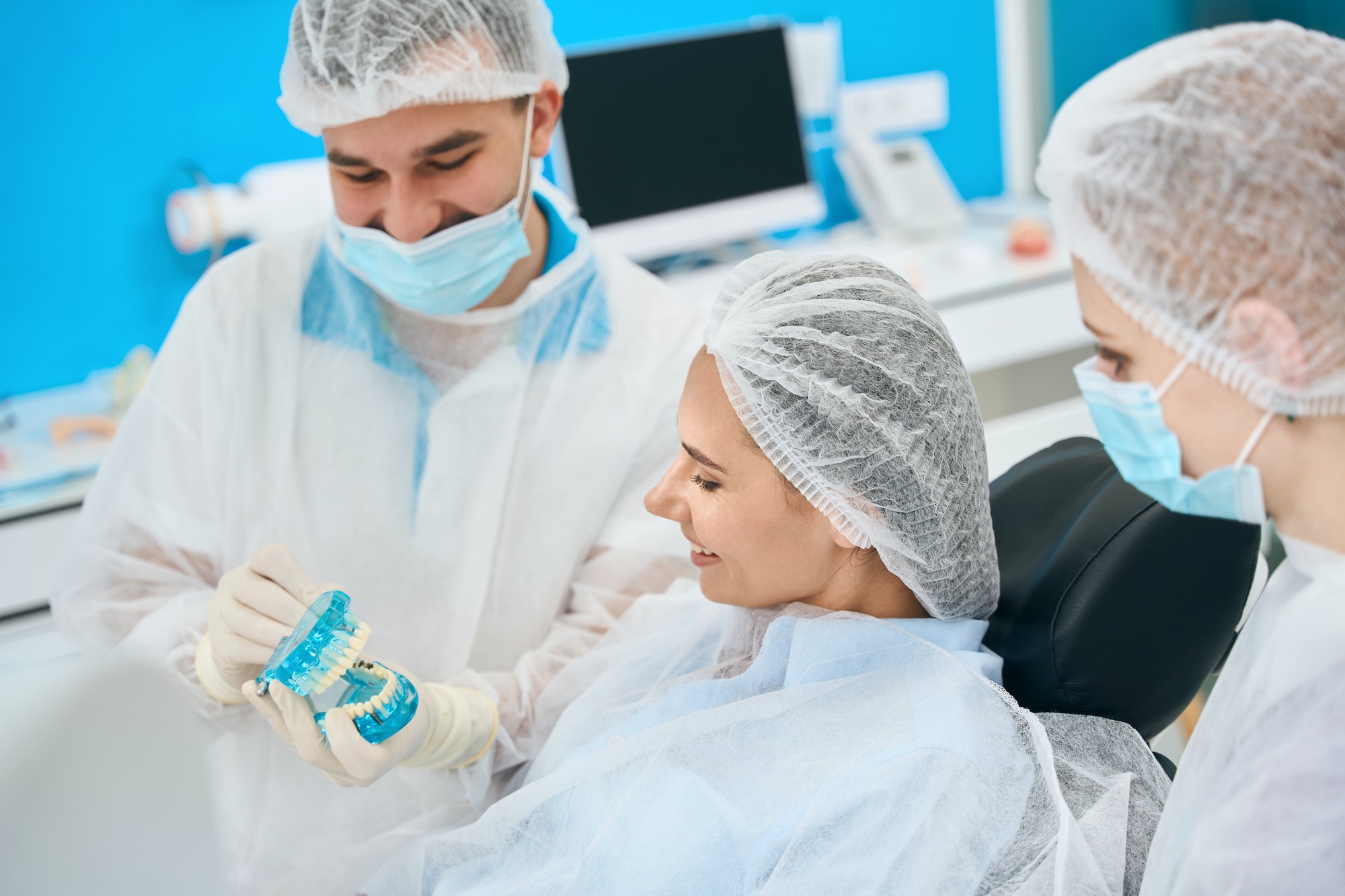 Woman examines a mock-up with dental implants